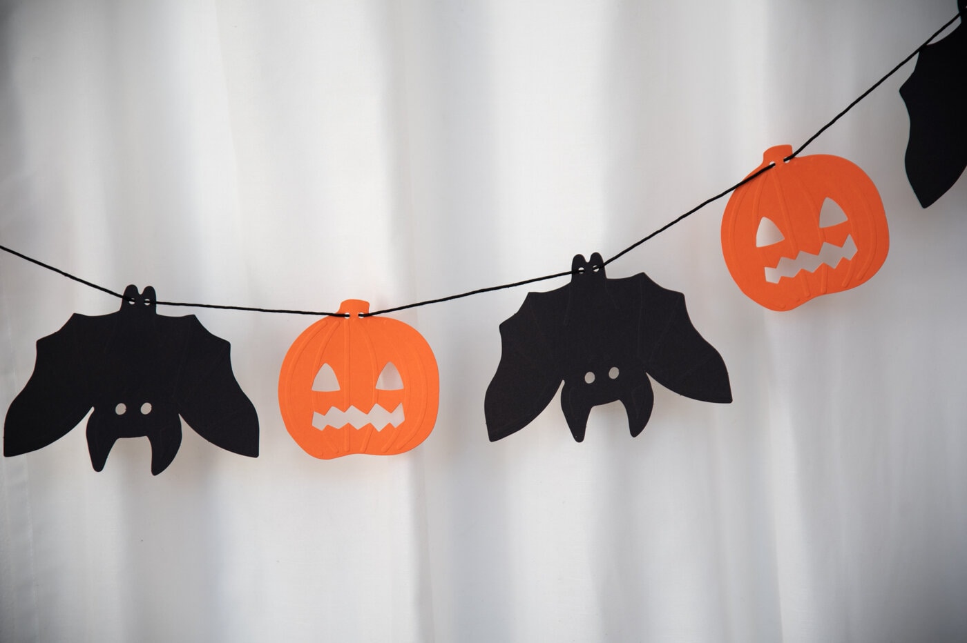 Halloween-girlander med svarte flaggermus og oransje gresskar.
