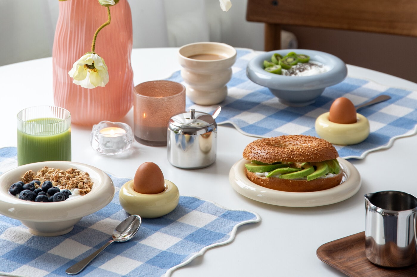 Frokost i lyseblå, rund skål med riflet glass på blårutet spisebrikke.