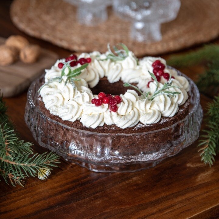 Rödvitt julgodis i glasskål mot rosa bakgrund.