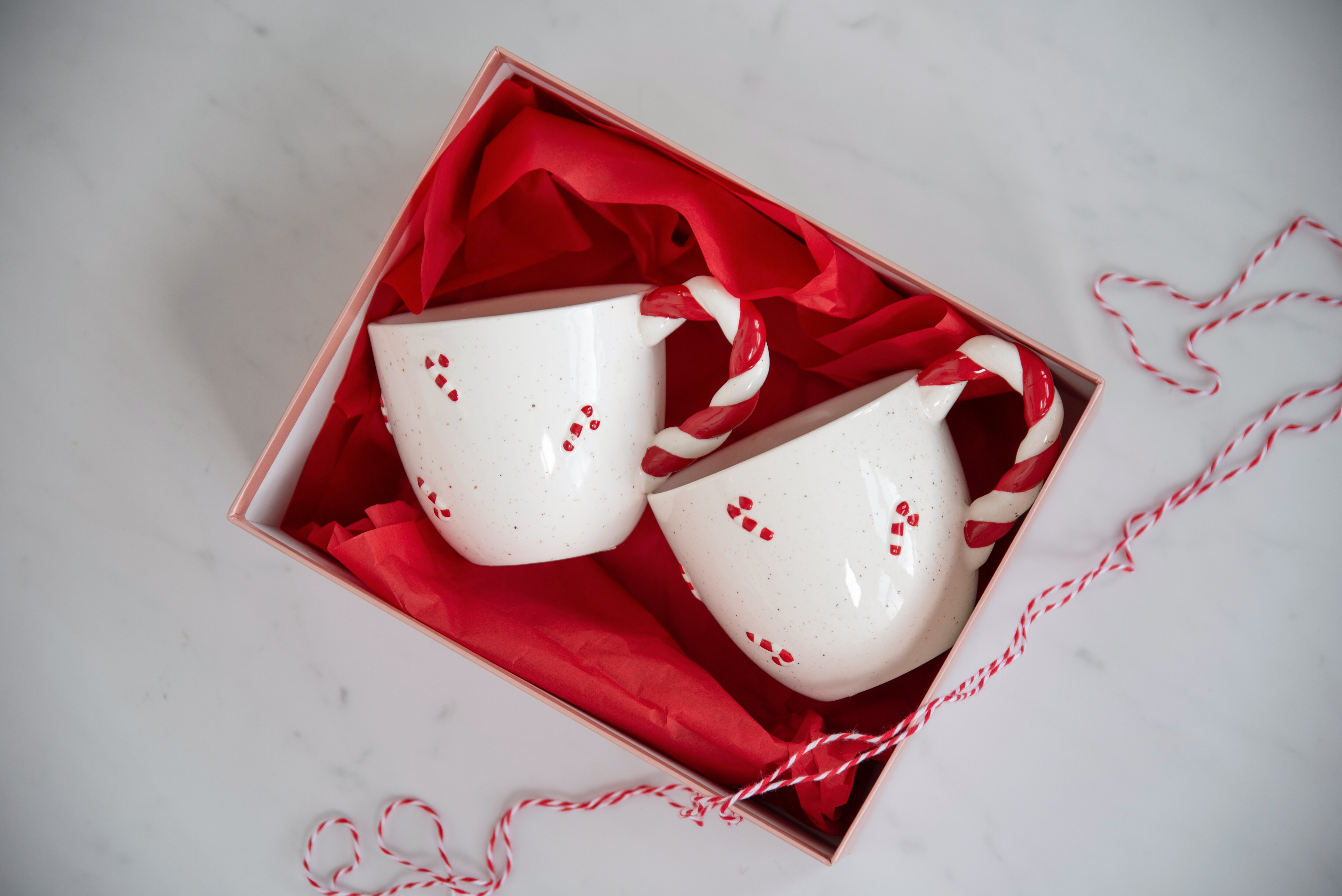 Røde og hvite lysestaker formet som sløyfer, med antikklys i ulike farger.