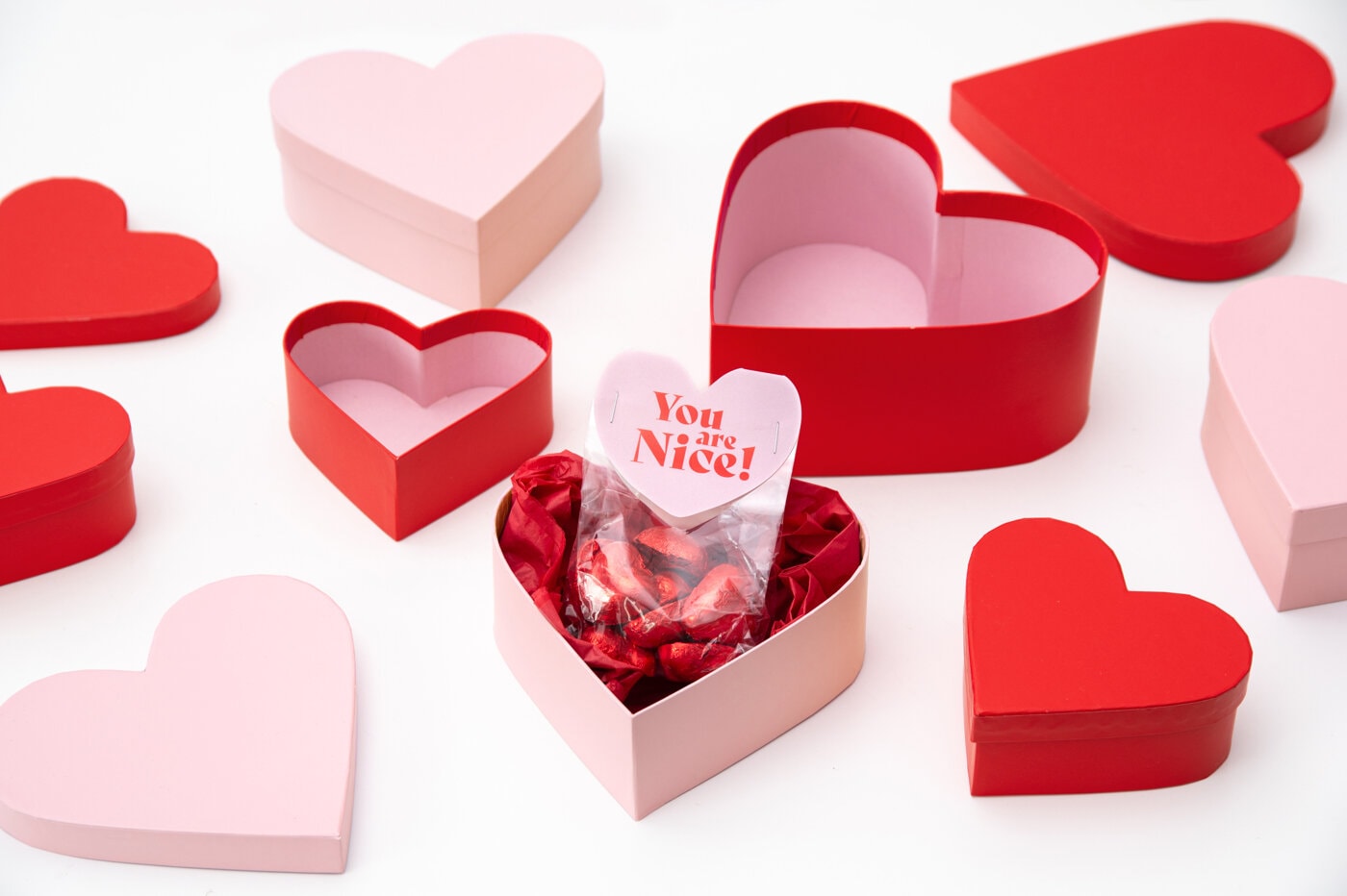 Hjerteformede esker i rødt og rosa mot hvit bakgrunn.