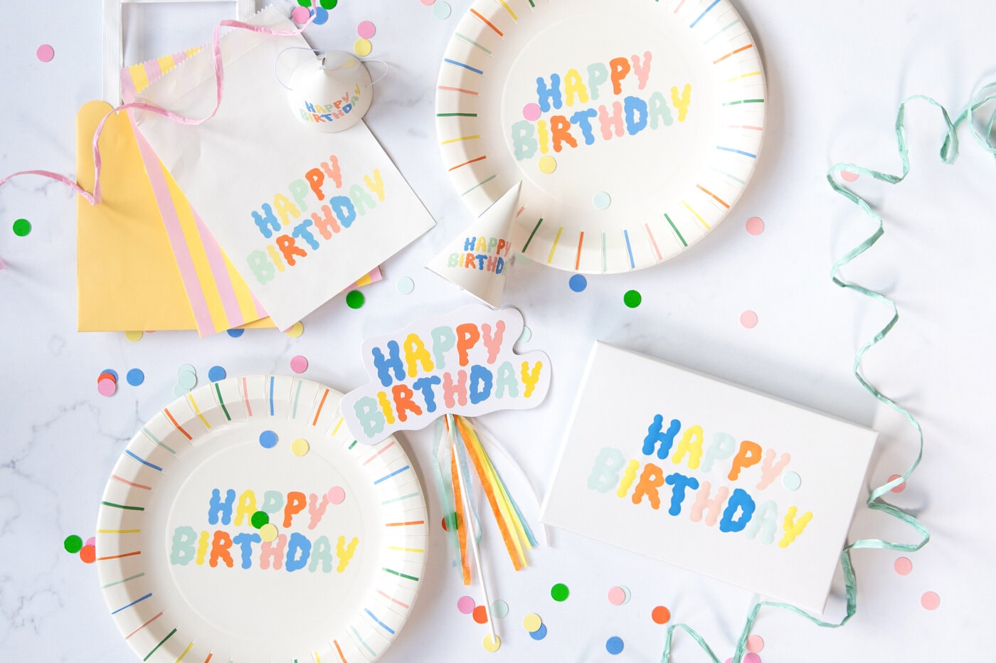 Engangsartikler til fest med fargerike tallerkener, servietter og dekor.