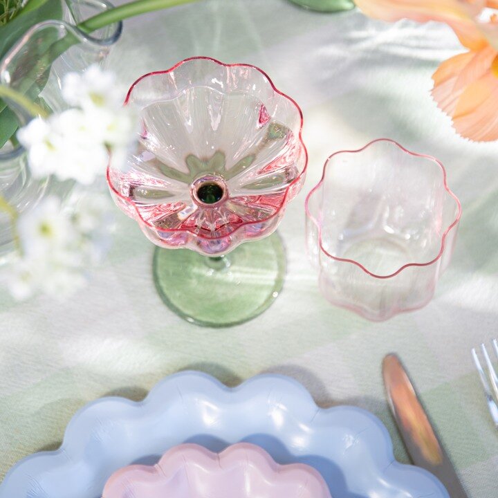Champagneglass formet som en blomst og pastellfargede papptallerkener