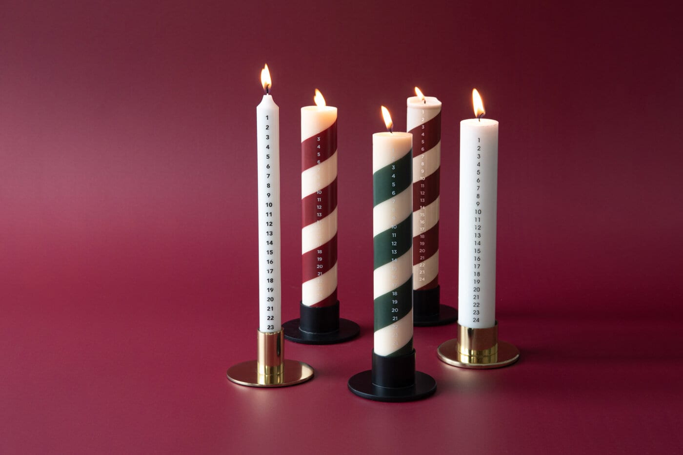 Hvit stearinlys buntet sammen med hyssing, plassert på kunstig snø.